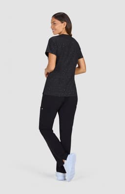 A black speckled top is displayed, paired with black pants and white shoes. The outfit appears casual and comfortable.