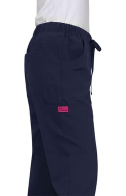 A pair of navy Aster Pants with pockets and an elastic waistband, featuring a pink branding tag.