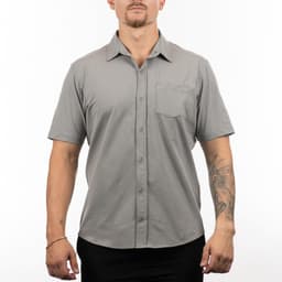 A short sleeve shirt in grey, featuring a button-up front and a chest pocket, displayed on a model.