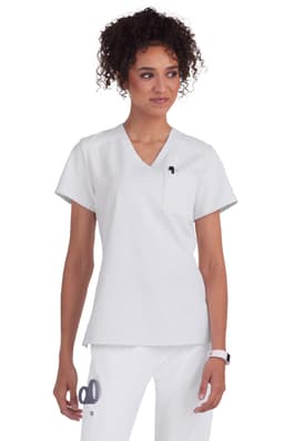 A medical scrub top in white, featuring a V-neck design and a pocket, worn by a woman with curly hair.