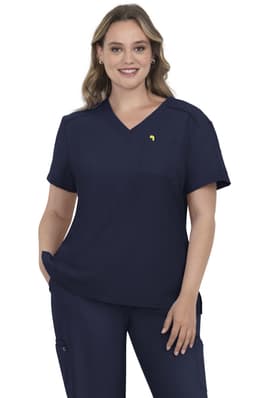 A navy blue scrub top featuring a V-neck design and a small logo. The model stands with hands on hips.