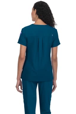 A woman wearing a teal medical scrub top, viewed from the back, featuring a logo on the shoulder.