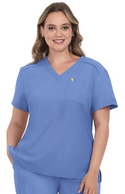 A scrub top in a light blue colour, featuring a V-neck and a chest pocket, worn by a model with wavy hair.