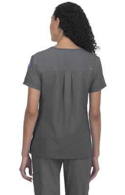A grey medical scrub top with a back pleat, featuring a logo on the sleeve.