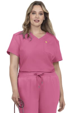 A pink scrub top with a short sleeve design and a chest pocket, worn by a model holding a medical stethoscope.