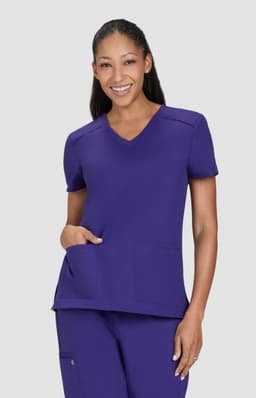 A purple medical scrub top with a V-neck and two front pockets, worn by a smiling model.