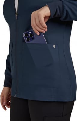 A women's navy jacket with a front zip and a pocket, where a smartphone is being placed. The jacket features a logo.