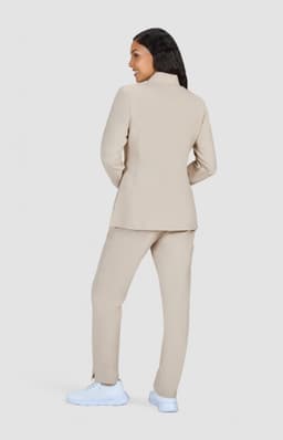 A beige women's jacket with matching pants, featuring a high collar and a simple design.