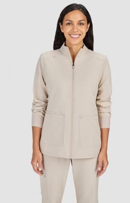 A beige women's jacket featuring a zip front and pockets, modelled by a woman with long hair.
