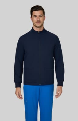 A navy blue men's jacket with a front zip and two pockets, worn over blue trousers. Features a logo.