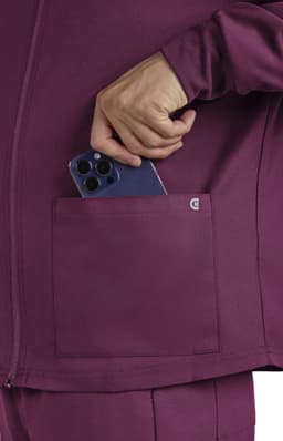 A maroon jacket with a pocket, featuring a hand placing a smartphone into it. The jacket has a logo.