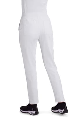 White Atria Pant displayed from the back, featuring a fitted design and pockets, paired with black footwear.