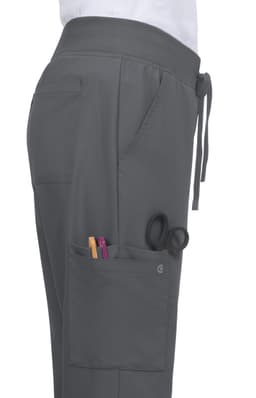 A grey pant featuring a drawstring waist and side pockets with pens and scissors visible. It has a logo on the fabric.