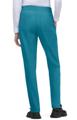 Atria Pant in teal, featuring a fitted design with back pockets. The model is shown from the back.