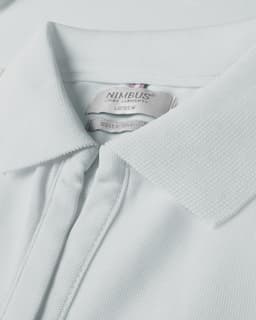 A light blue polo shirt featuring a classic collar and a small logo on the neck tag.