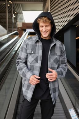A grey and black check shirt jacket with a hood, featuring buttons and a casual fit. It has a logo present.