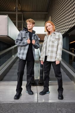 A check shirt jacket in grey and white, worn by a man and woman, paired with black pants and shoes.
