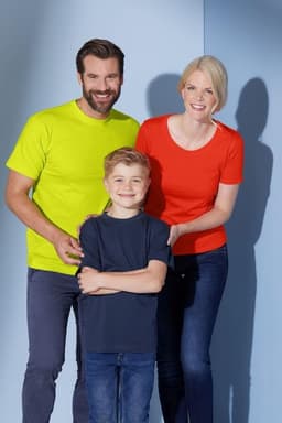 A man in a bright yellow t-shirt, a woman in a red t-shirt, and a boy in a navy t-shirt pose together.