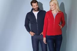 A navy men's jacket and a red women's jacket are displayed on two models against a soft blue background.