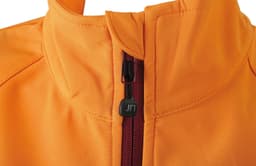 An orange softshell jacket featuring a zippered front and a high collar, with a small logo on the zipper.