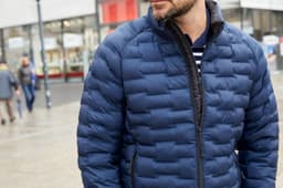 A men's modern padded jacket in navy blue, featuring a zip front and a quilted design. The jacket has a logo on it.