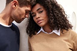 A brown round-neck pullover worn by a model, alongside a model in a navy pullover, both against a neutral background.