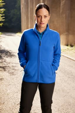 A blue bonded fleece jacket with a zip front and side pockets, worn by a woman in a natural setting.