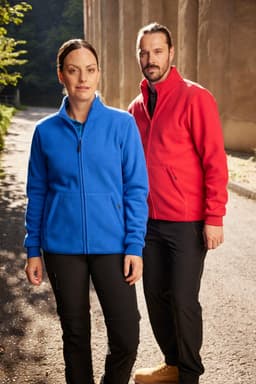 A blue fleece jacket on a woman and a red fleece jacket on a man, both standing outdoors.