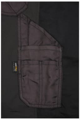 A close-up view of black workwear stretch-pants featuring multiple pockets and a branding label.