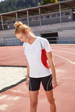 A women's running T-shirt in white with red accents, paired with black shorts, suitable for sporting activities.