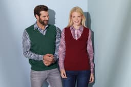 A green and a burgundy ladies' v-neck vest are worn over checkered shirts. The image features two smiling models.