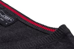 A close-up of a dark grey knitted men's V-neck vest with a red striped neckline and a label visible.