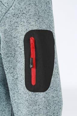 A close-up of a ladies' knitted fleece jacket in grey, featuring a red zippered pocket on the arm.