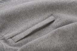 A grey sweat jacket featuring a concealed pocket detail and a soft fabric texture.
