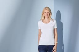A white ladies' t-shirt with a round neckline and short sleeves, modelled by a woman against a blue background.