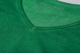 A green ladies' t-shirt features a v-neck design and a smooth fabric texture. It has a logo at the neckline.