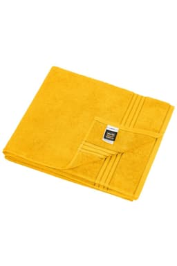 A folded yellow sauna sheet made of soft towel-like fabric, featuring a logo tag on one corner.