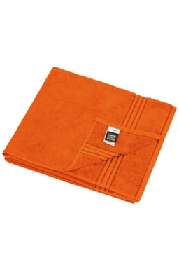 An orange towel folded neatly, featuring a textured pattern and a label on one corner.