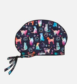 A printed unisex bouffant cap featuring a colourful pattern of dogs and paw prints on a dark background.