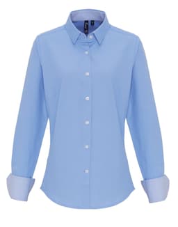 A light blue women's cotton-rich button-up shirt with a classic collar and striped cuffs. Features a logo.