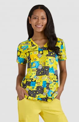 A vibrant yellow top featuring various playful prints, paired with yellow pants, worn by a woman smiling.