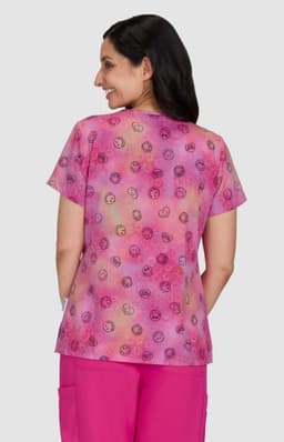 A short-sleeved top featuring a vibrant pink and purple pattern, with a soft fabric and a logo on the back.