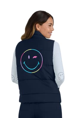 A navy vest featuring a large, colourful smiley face on the back, worn by a woman with long hair.
