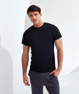 A black performance t-shirt displayed on a male model against a minimalist backdrop, showcasing its fit and style.