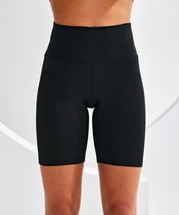 Black legging shorts with a high waist displayed on a model against a light background. Features a simple design.