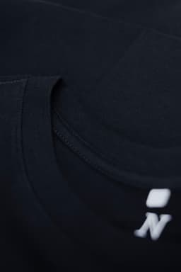 A black T-shirt featuring a crew neck design and a small logo on the neckline.