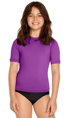 A young girl is wearing a purple short sleeve rashie, paired with black swim bottoms. The product features a logo.