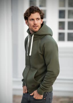 A man wearing an olive green hoodie with a front pocket and drawstring hood, featuring a logo.