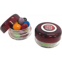 A small screw cap jar with a red lid filled with colourful choc beans, beside another similar jar.