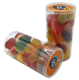 A clear tube filled with mixed lollies in various colours, including red, yellow, green, and orange. The tube features a branding logo.